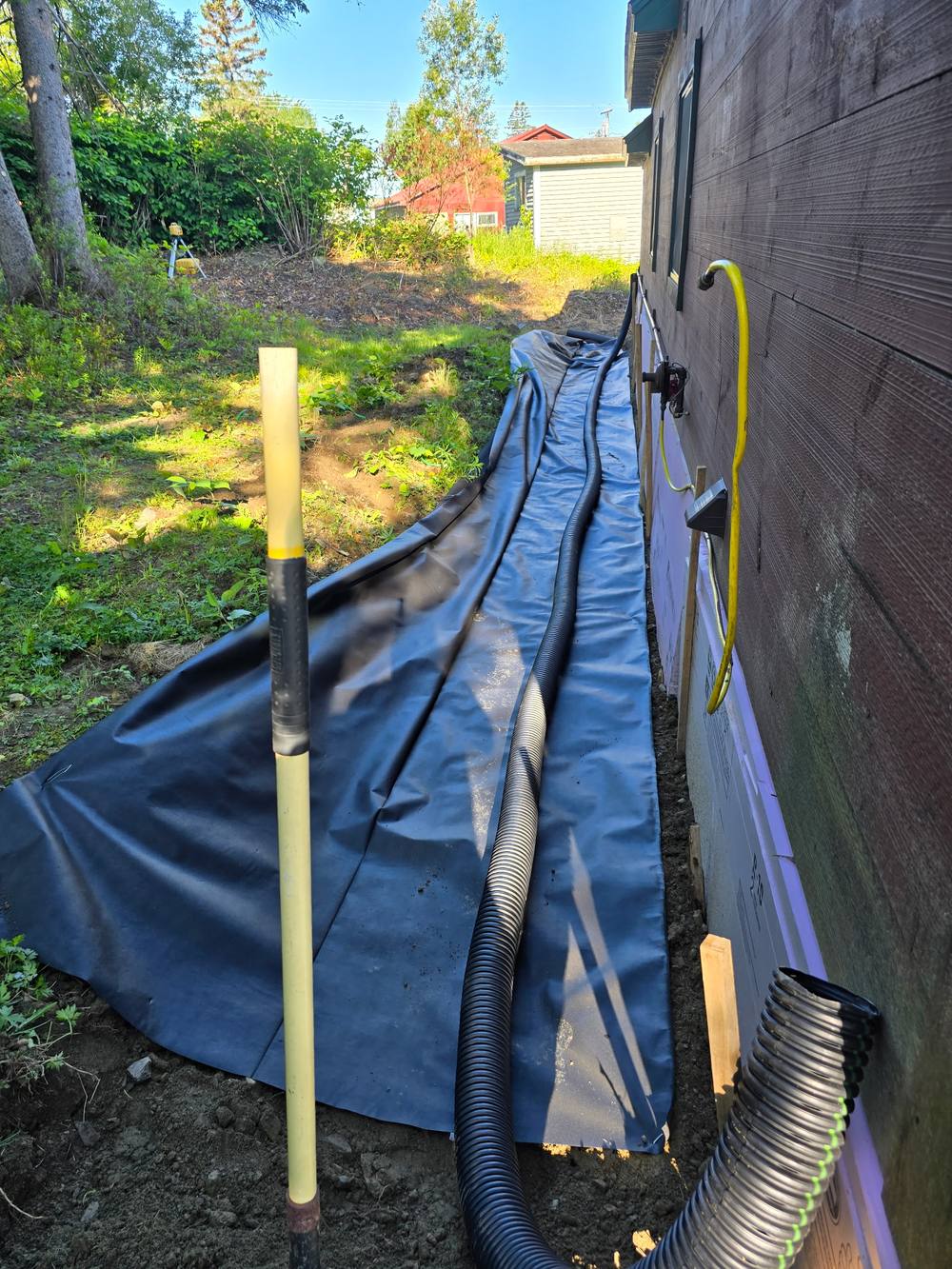 French drain and drainage pipe installation along a foundation