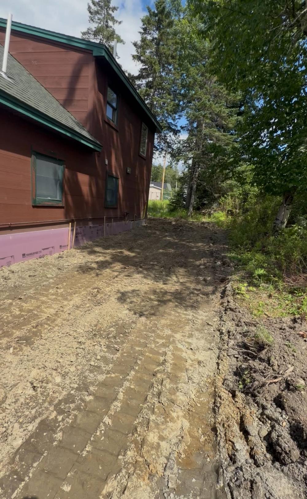 Excavation along a home foundation with insulation board exposed