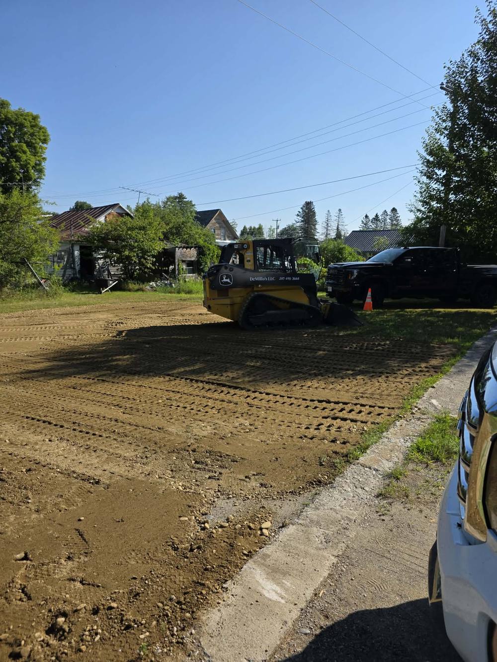 DeMillo's Excavation skid steer and truck on a residential job site